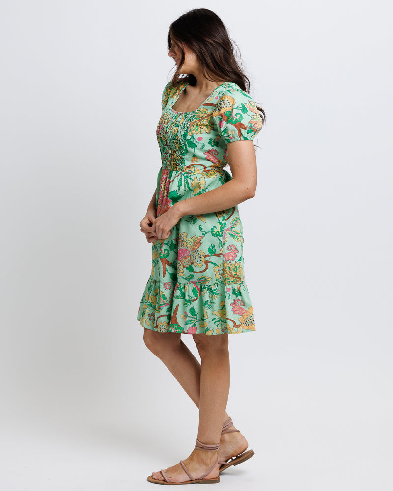 Model wearing a green with pink and yellow floral print short sleeve square neck knee length dress.