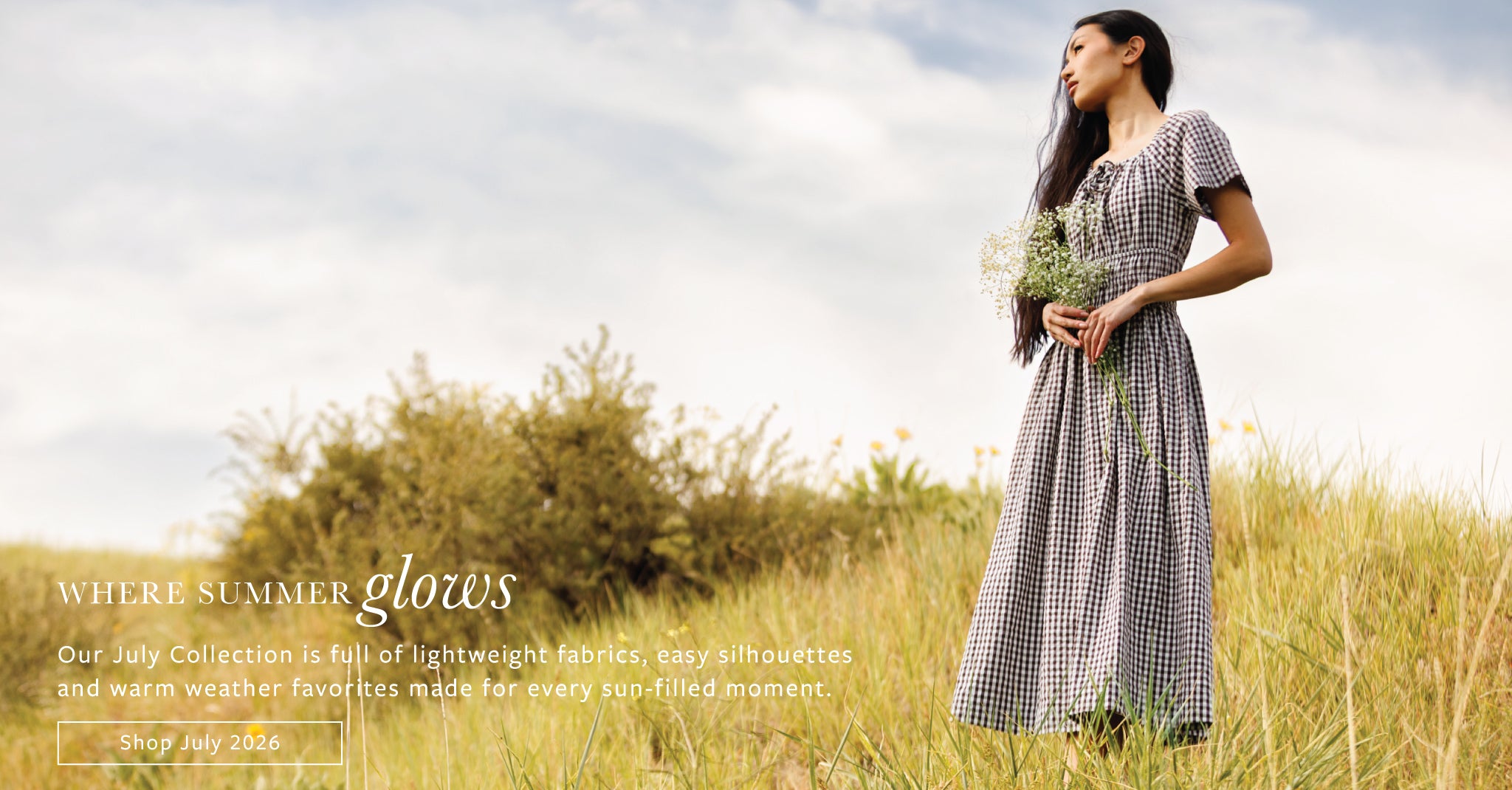 A woman stands in a grassy field wearing a loose, short-sleeve gingham dress and holding a small bouquet of wildflowers. Text on the left reads 'WHERE SUMMER glows' with a shopping link.