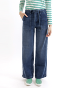 Woman wearing a green and white striped shirt and blue jeans on a white background