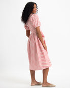 Woman wearing a red and white striped dress on a white background