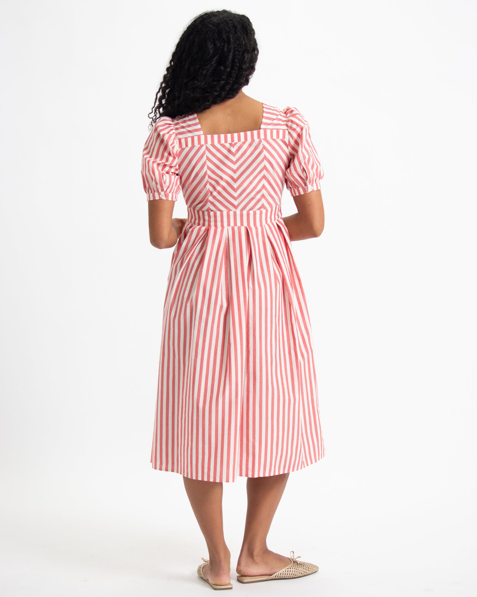 Woman wearing a red and white striped dress on a white background