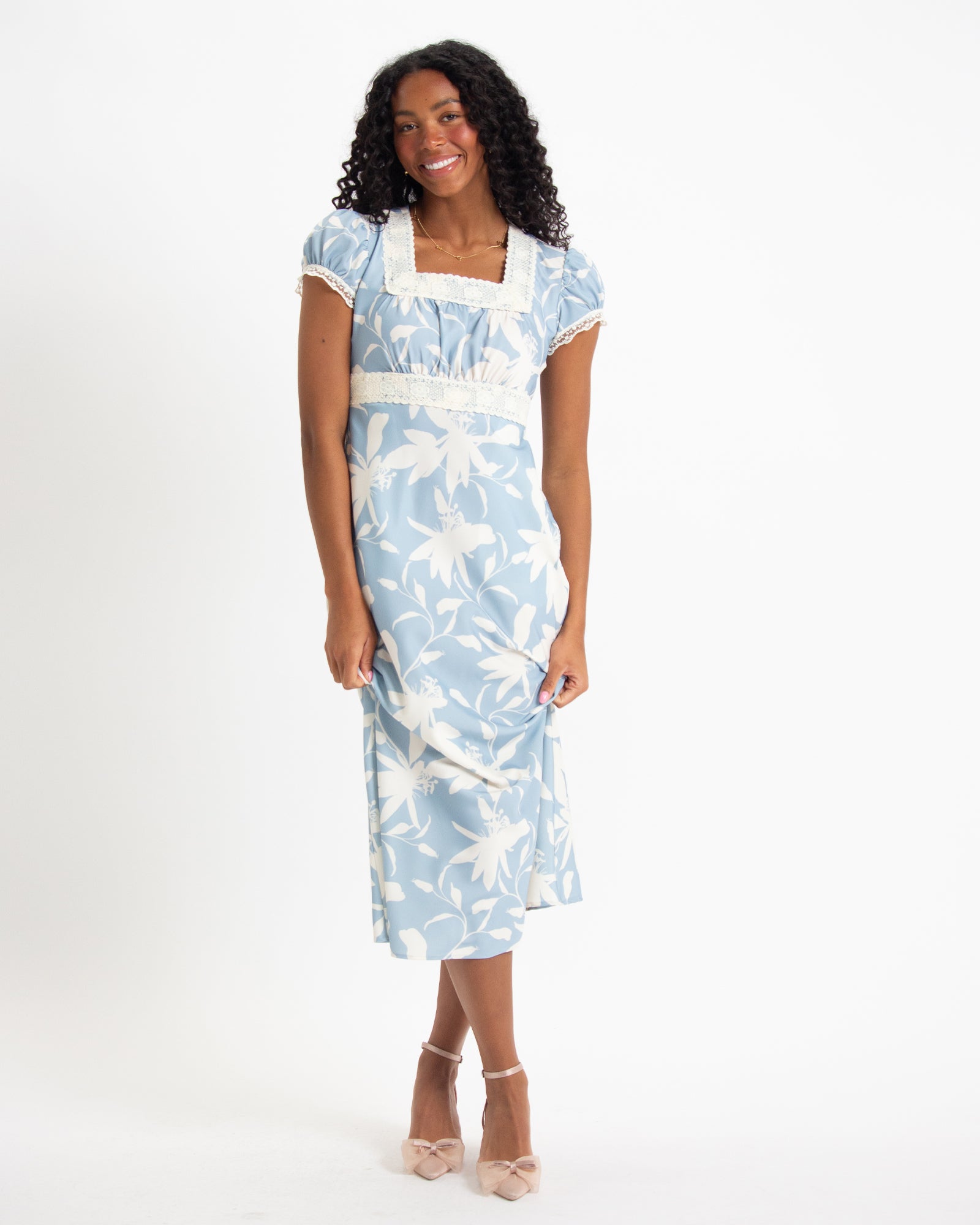 Woman wearing a blue floral dress on a white background