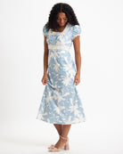 Woman wearing a blue floral dress on a white background