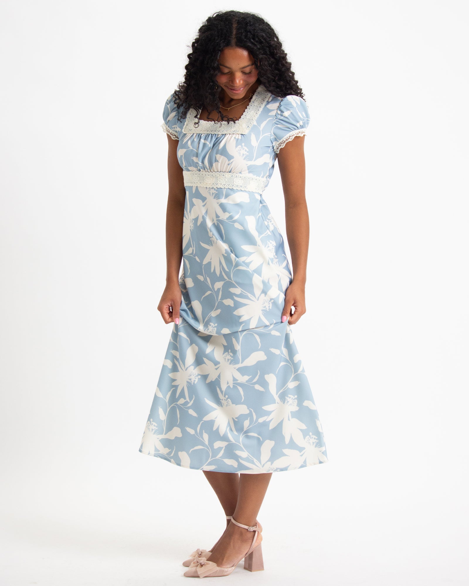 Woman wearing a blue floral dress on a white background