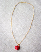 Necklace with a red heart pendant on a light gray background