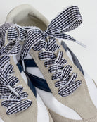Pair of shoes with gingham ribbon details on a white background