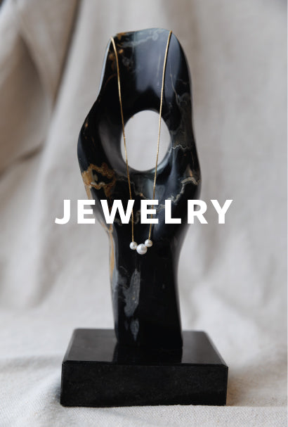 Image of a pearl necklace on a black figurine with JEWELRY text