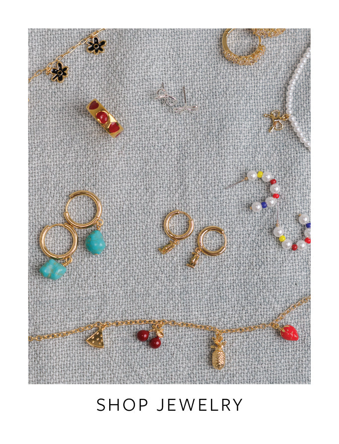 Collection of various jewelry pieces on a textured gray background with 'Shop Jewelry' text.