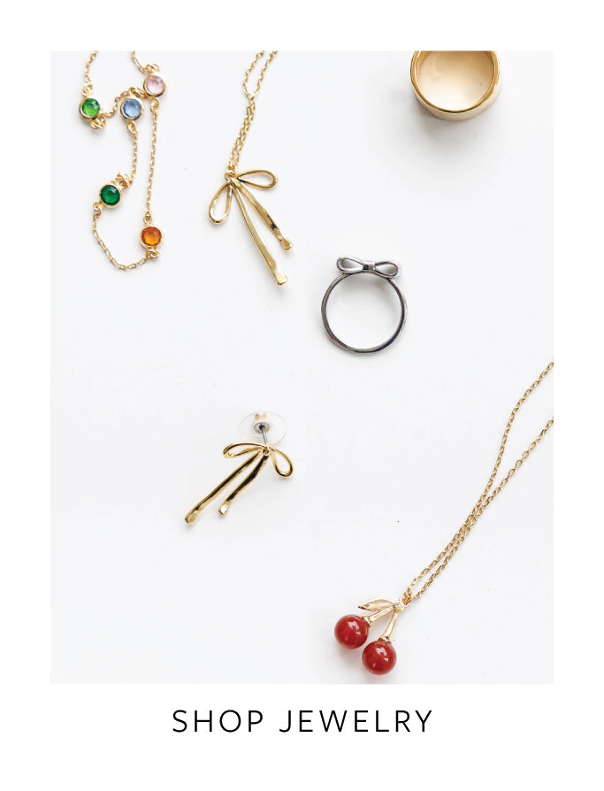 Jewelry including necklaces, earrings, and a ring on a white background with 'Shop Jewelry' text.