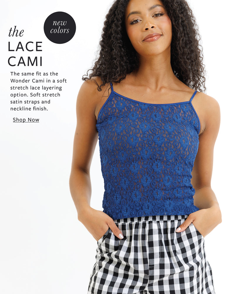 Woman wearing a blue lace cami with checkered pants on a white background