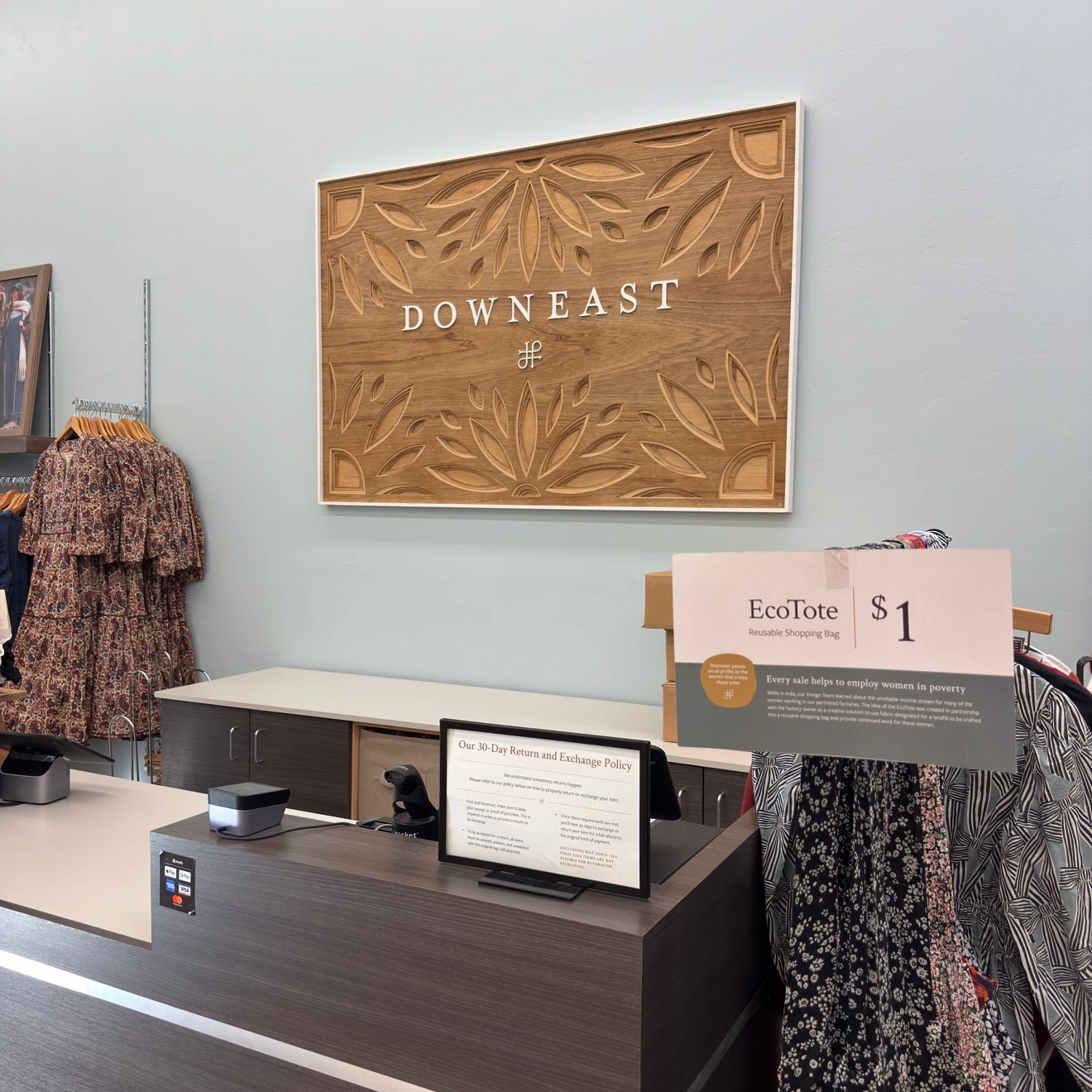 Store interior with 'Downeast' sign above a cashier counter, featuring an EcoTote sign.