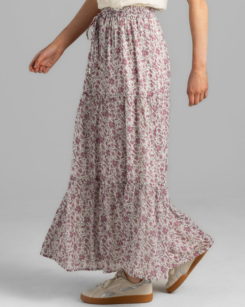 Model wearing a pink floral print tiered maxi skirt.