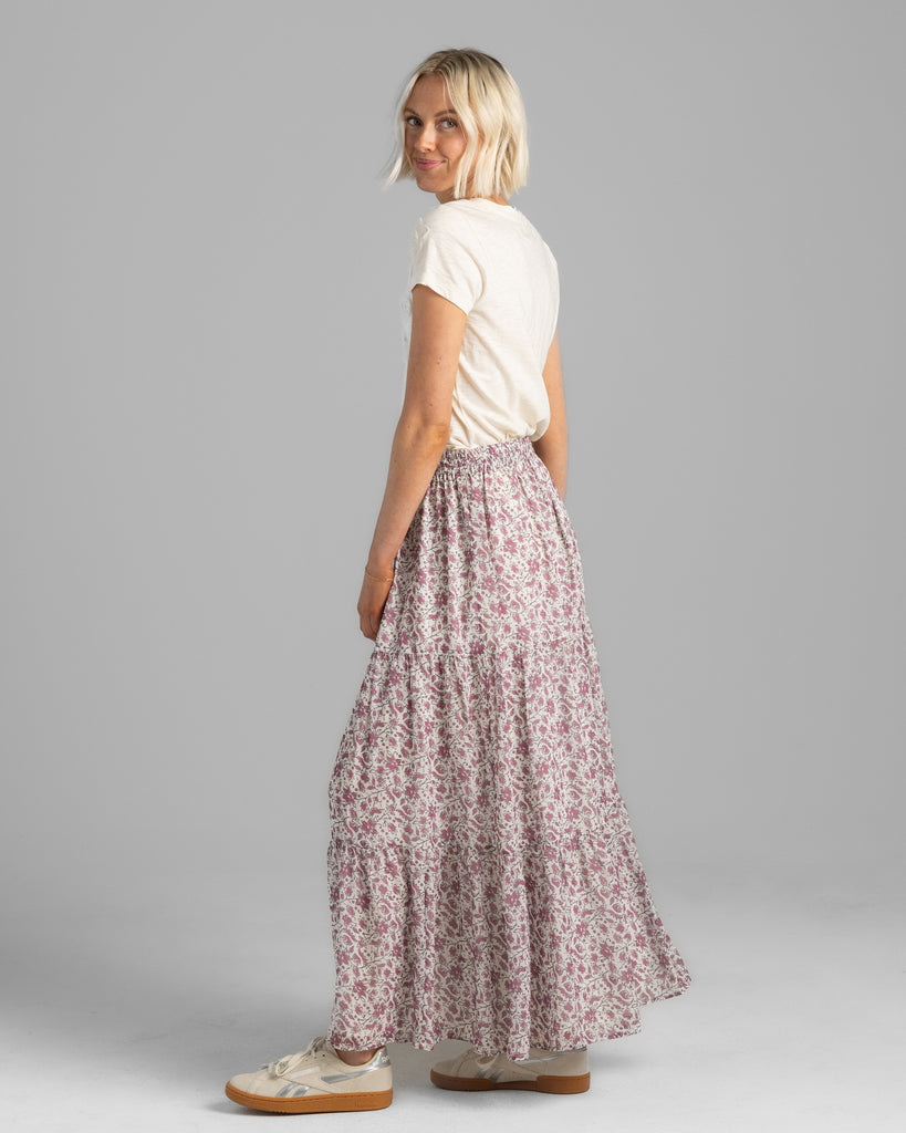 Model wearing a pink floral print tiered maxi skirt.