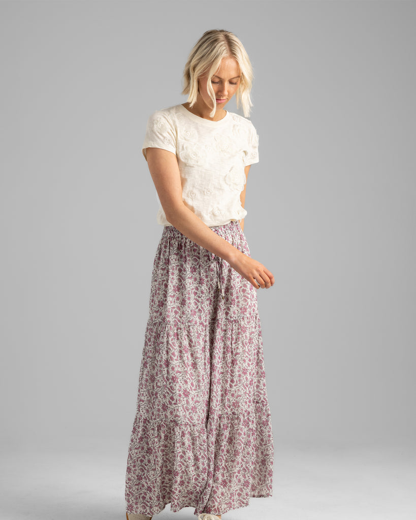 Model wearing a pink floral print tiered maxi skirt.