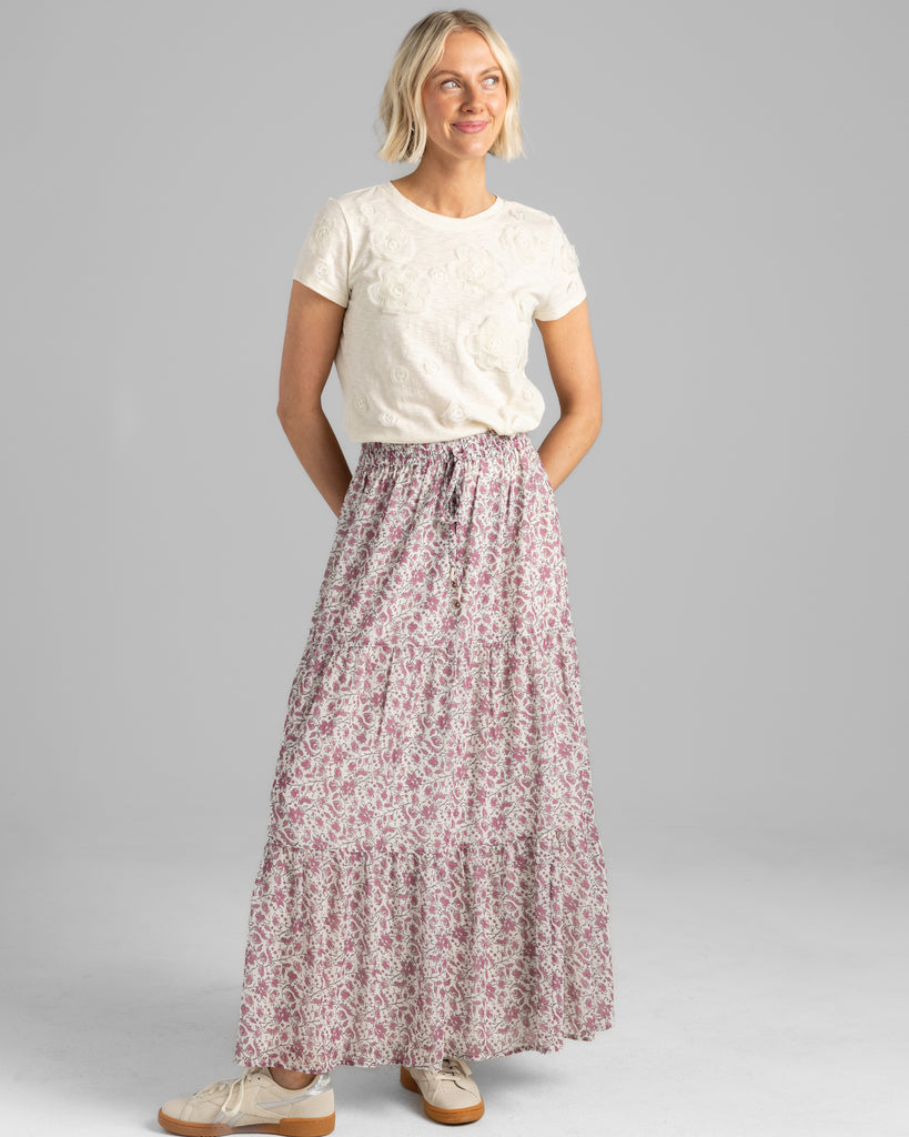 Model wearing a pink floral print tiered maxi skirt.