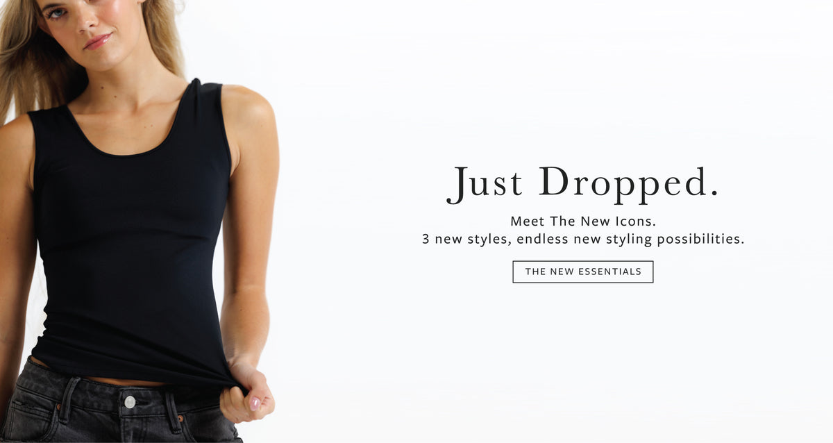 A woman wearing a black sleeveless tank top and dark jeans, shown against a plain white background with promotional text on the right reading 'Just Dropped. Meet The New icons.