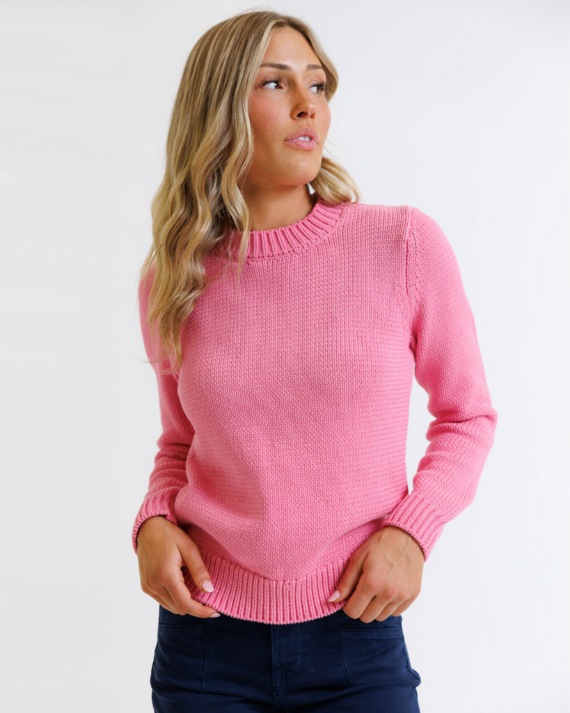 Woman wearing a pink sweater against a white background