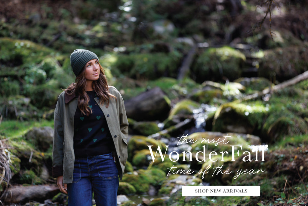 Woman in a forest with promotional text overlay says "The Most WonderFall Time of the Year" and has a button that says "Shop New Arrivals"