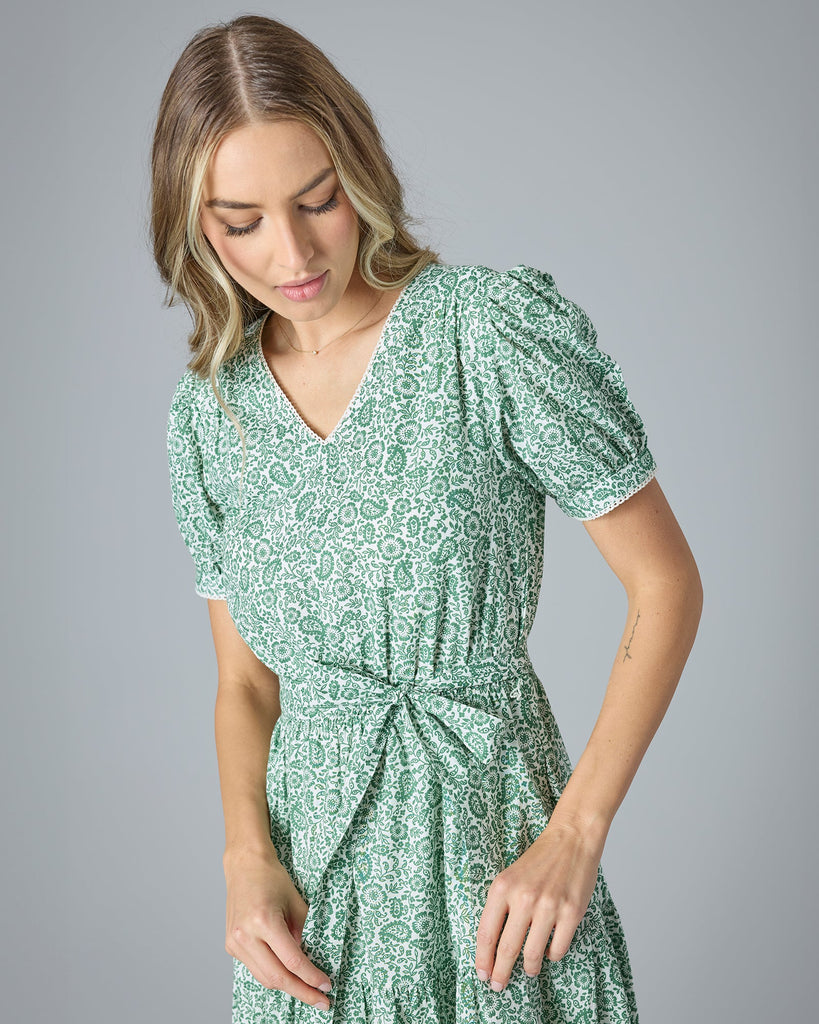 Woman in a green floral midi-length short sleeve dress