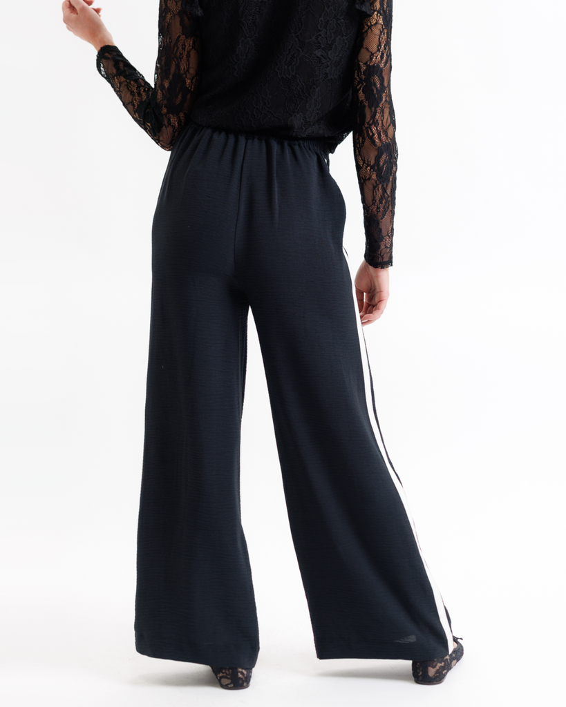Black wide-leg pants with a white stripe on a white background