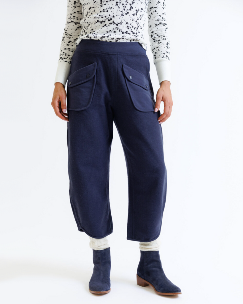 Person wearing navy blue pants with front pockets on a white background