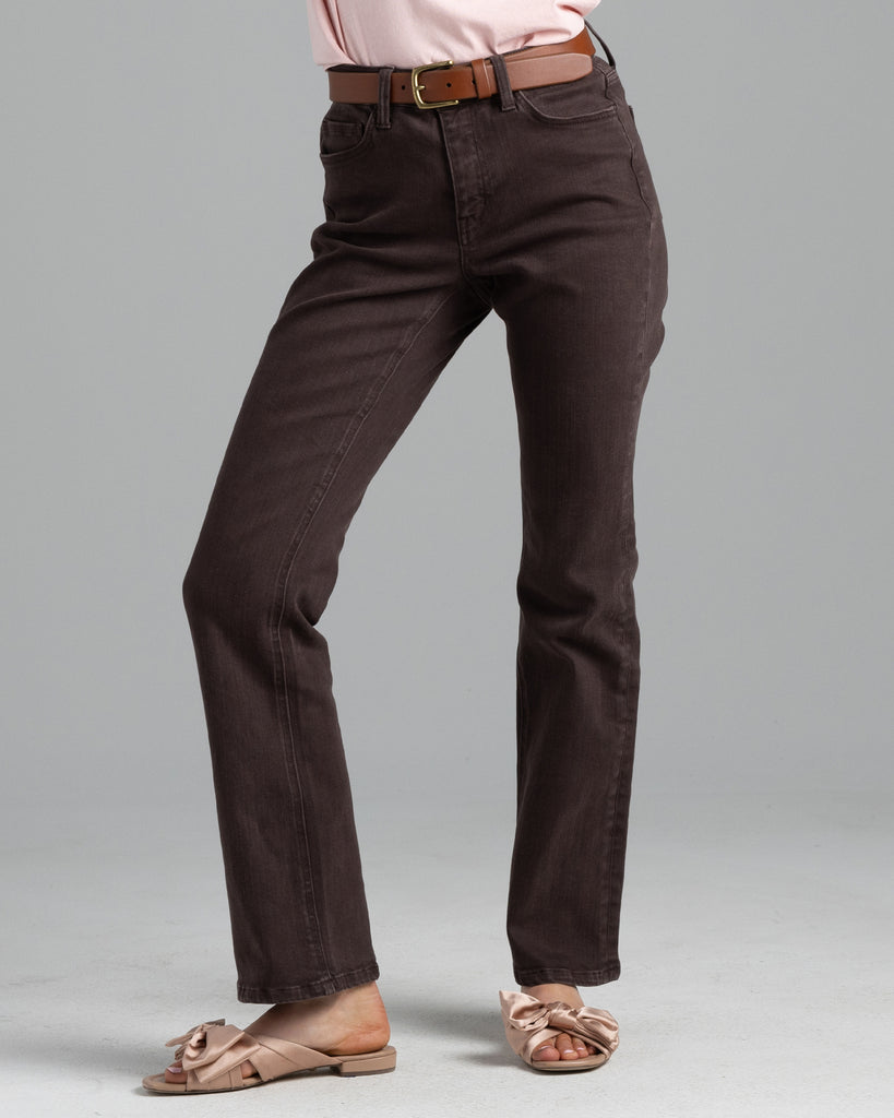 Model wearing a dark brown pair of bootcut, ankle length denim jeans.