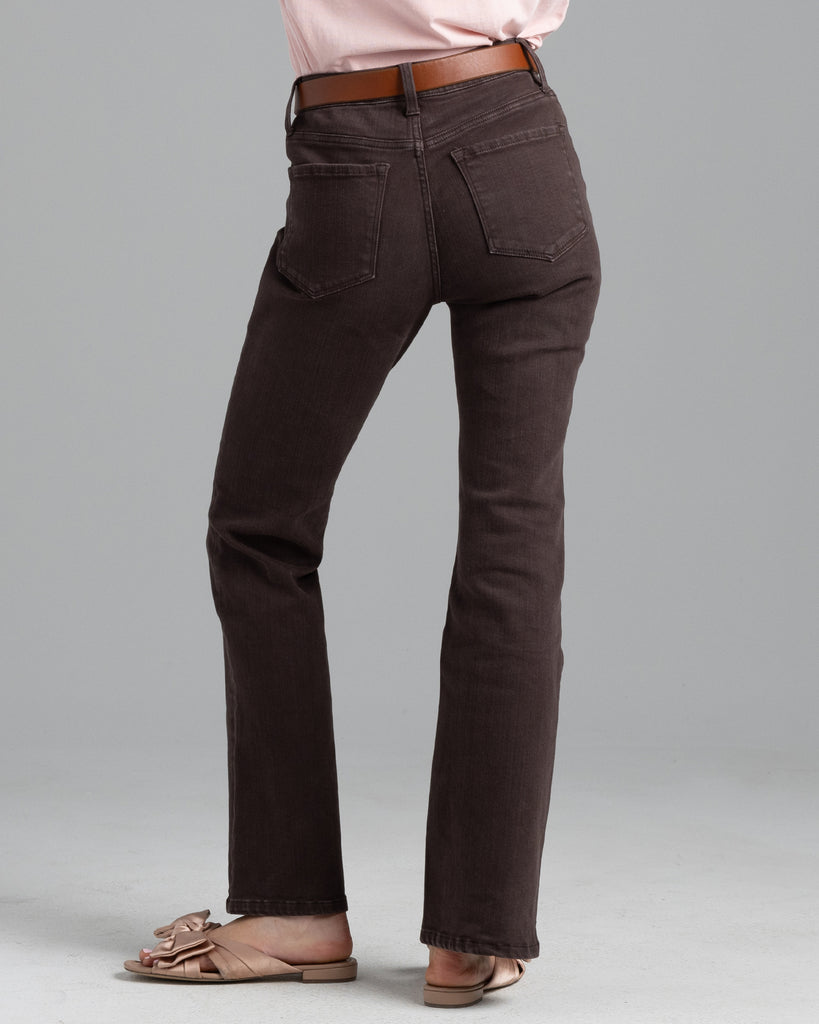 Model wearing a dark brown pair of bootcut, ankle length denim jeans.