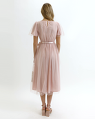 Woman wearing a light pink dress on a white background