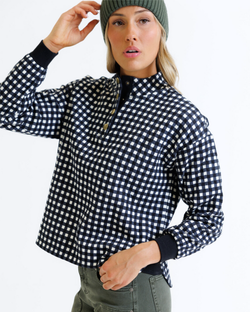 Woman wearing a black and white checkered pullover on a white background