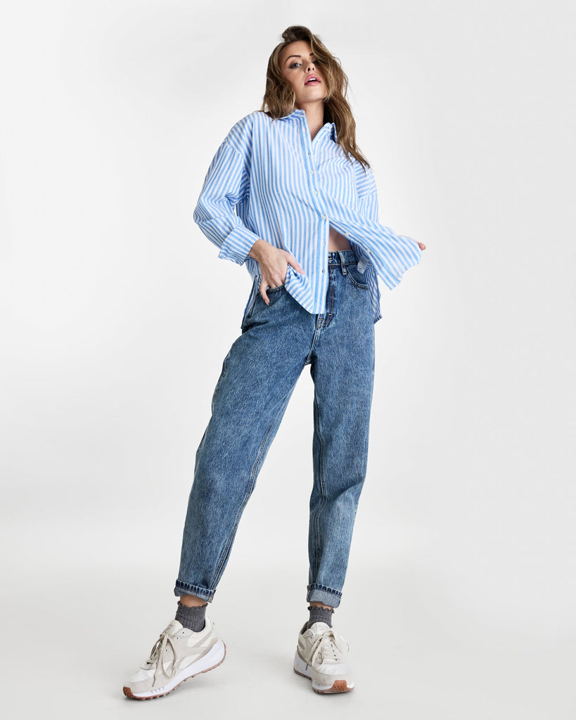 Woman in a long sleeve, striped, buttondown top