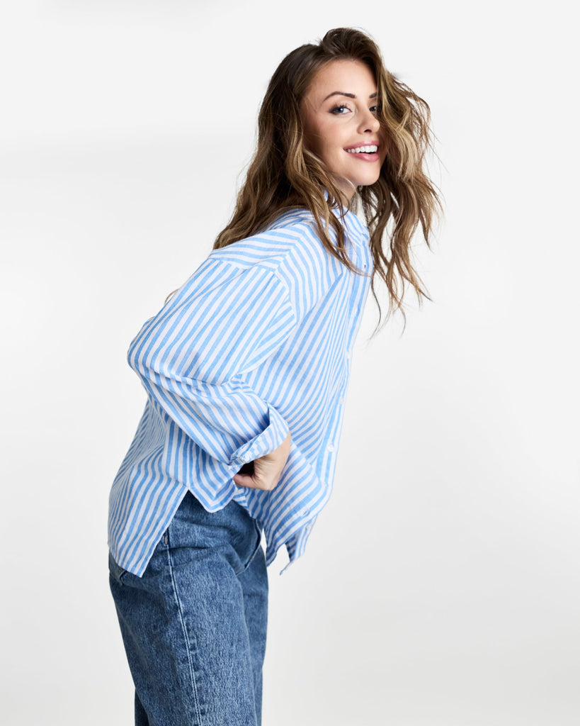 Woman in a long sleeve, striped, buttondown top