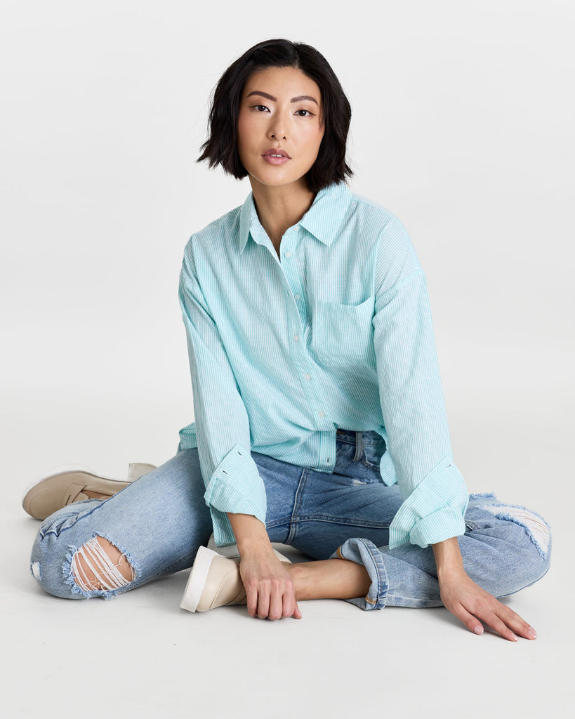 Woman in a long sleeve, striped, buttondown top