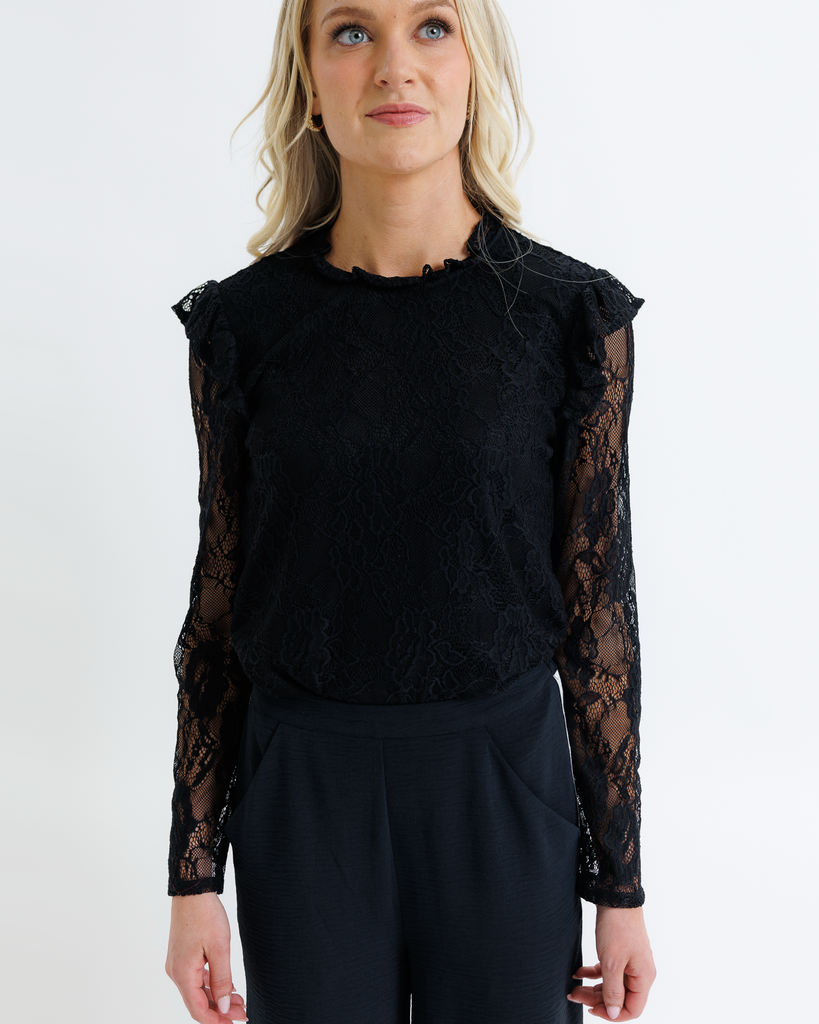 Woman wearing a black lace long-sleeve top against a white background