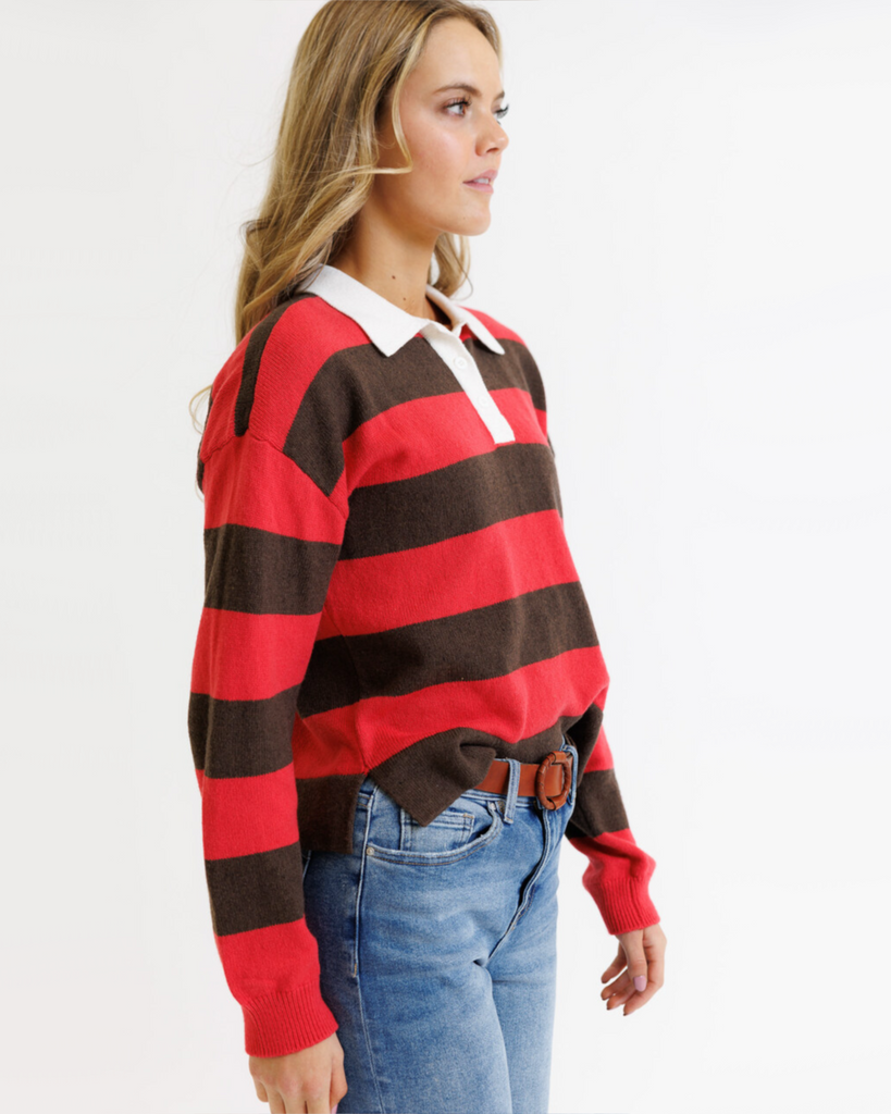 Woman wearing a red and brown striped sweater with a white collar on a white background