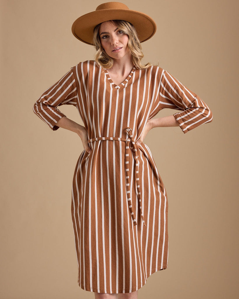 Woman in a 3/4 sleeve, knee-length, brown vertical stripe dress