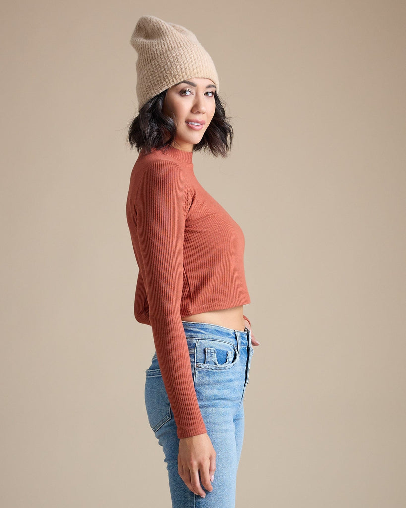 Woman in a burnt orange long sleeve ribbed cropped tee