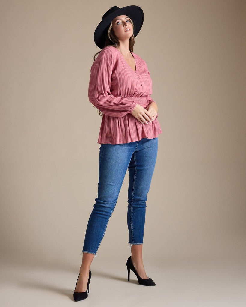 Woman in a pink long sleeve peplum blouse