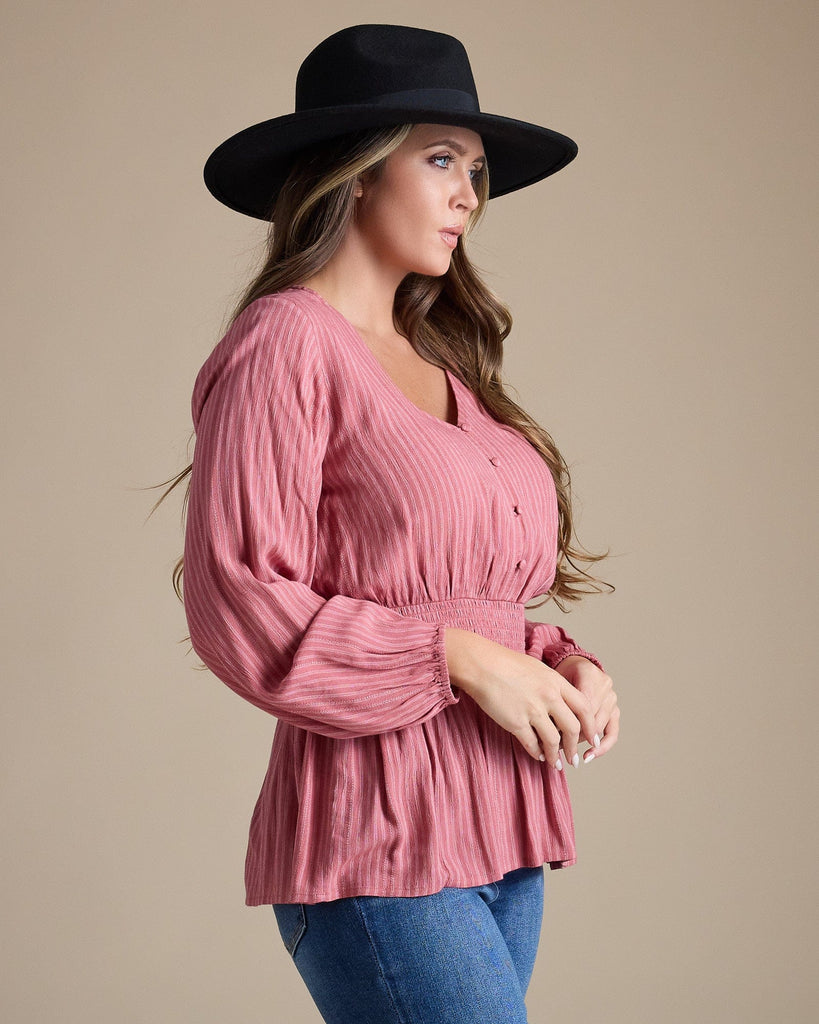 Woman in a pink long sleeve peplum blouse