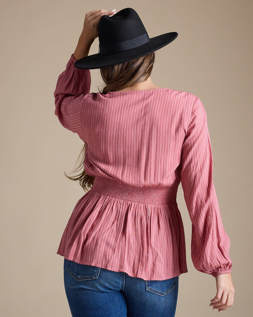 Woman in a pink long sleeve peplum blouse