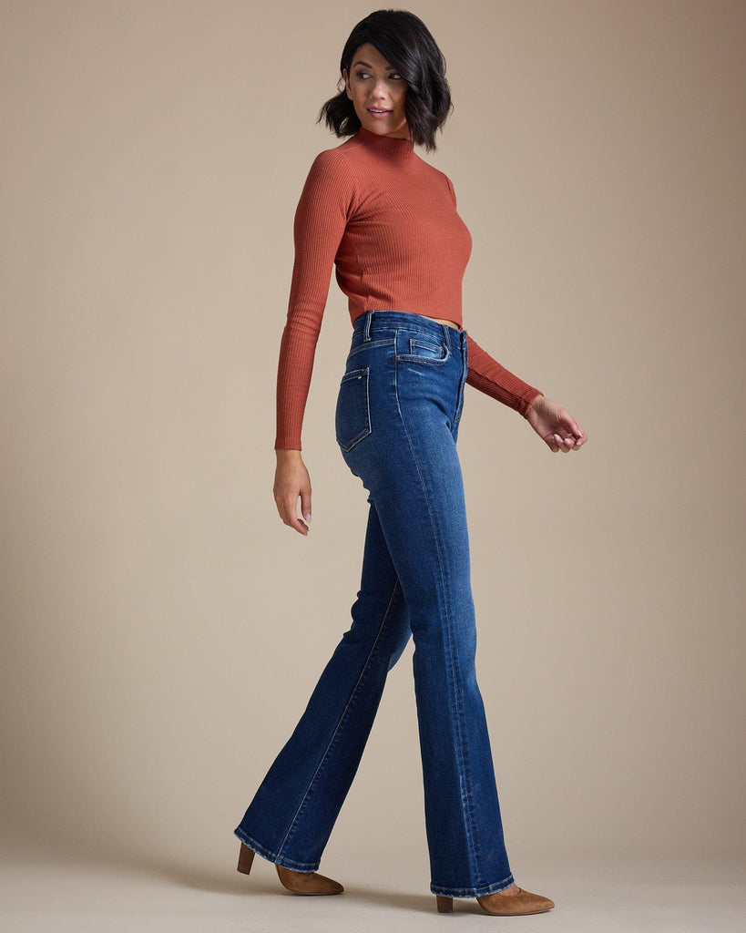 Woman in blue high-rise bootcut jeans