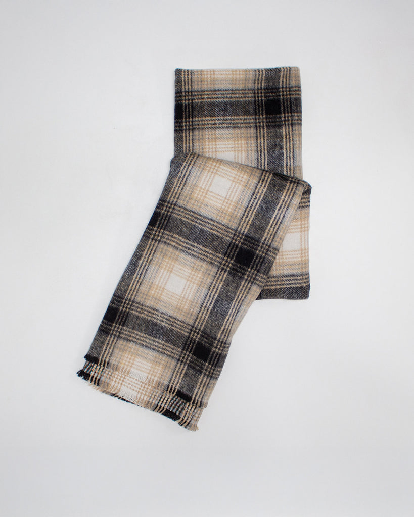 Plaid scarf with beige and black pattern on a white background