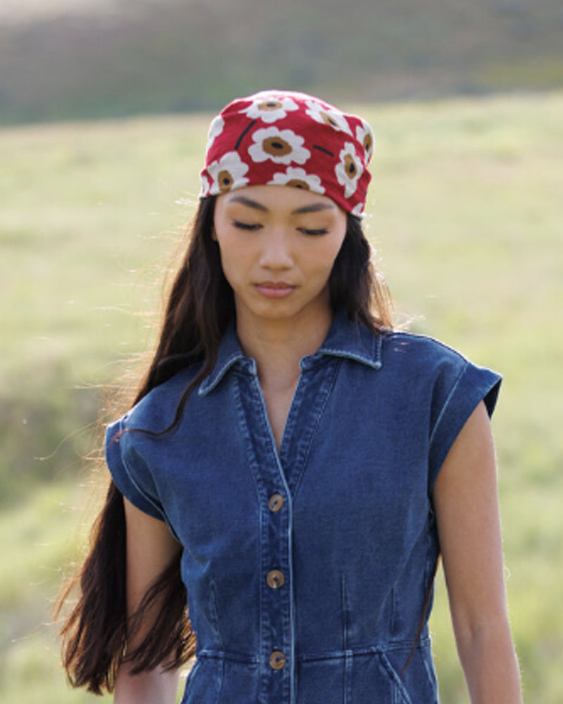 Woman wearing a red floral headscarf in a field
