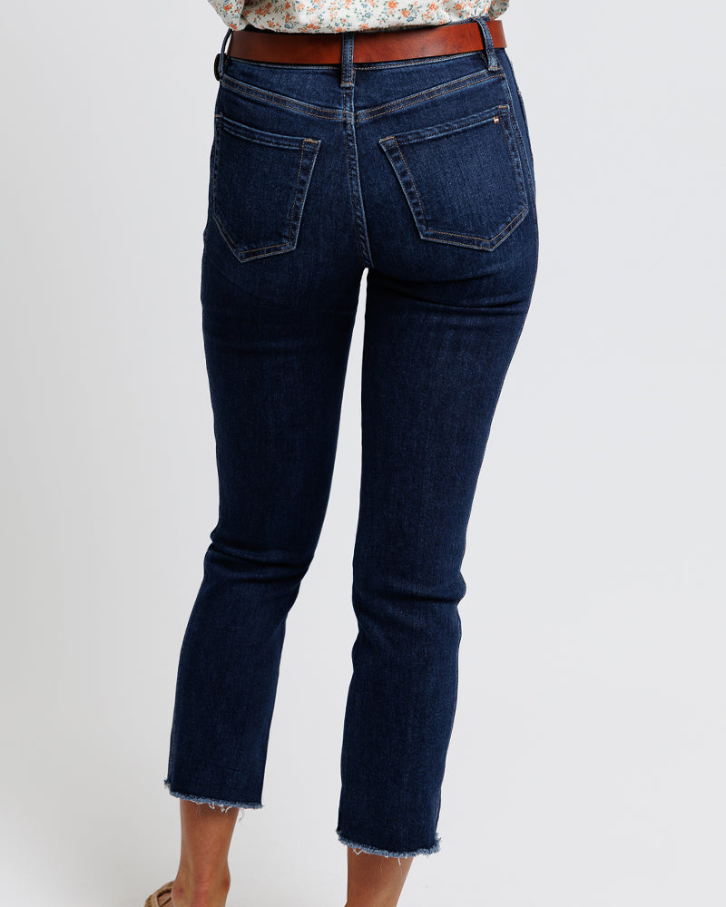 Model wearing dark blue mid-rise cropped denim jeans.