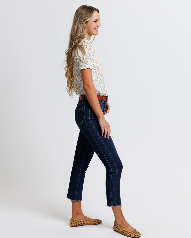 Model wearing dark blue mid-rise cropped denim jeans.