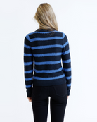 Woman wearing a black and blue striped sweater on a white background