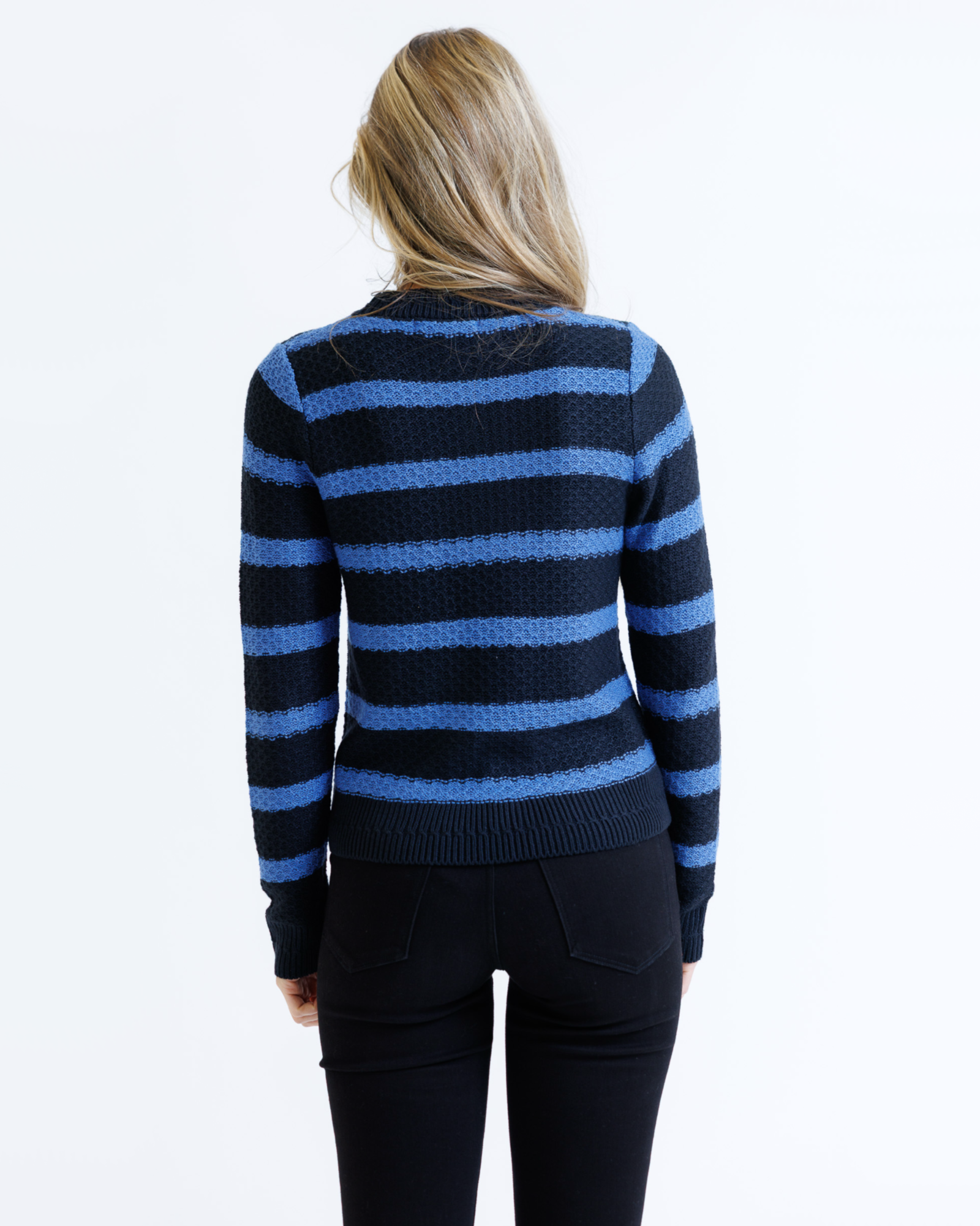 Woman wearing a black and blue striped sweater on a white background