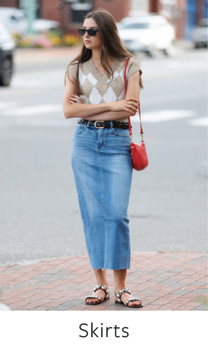 Woman wearing a denim skirt with a blurred street background