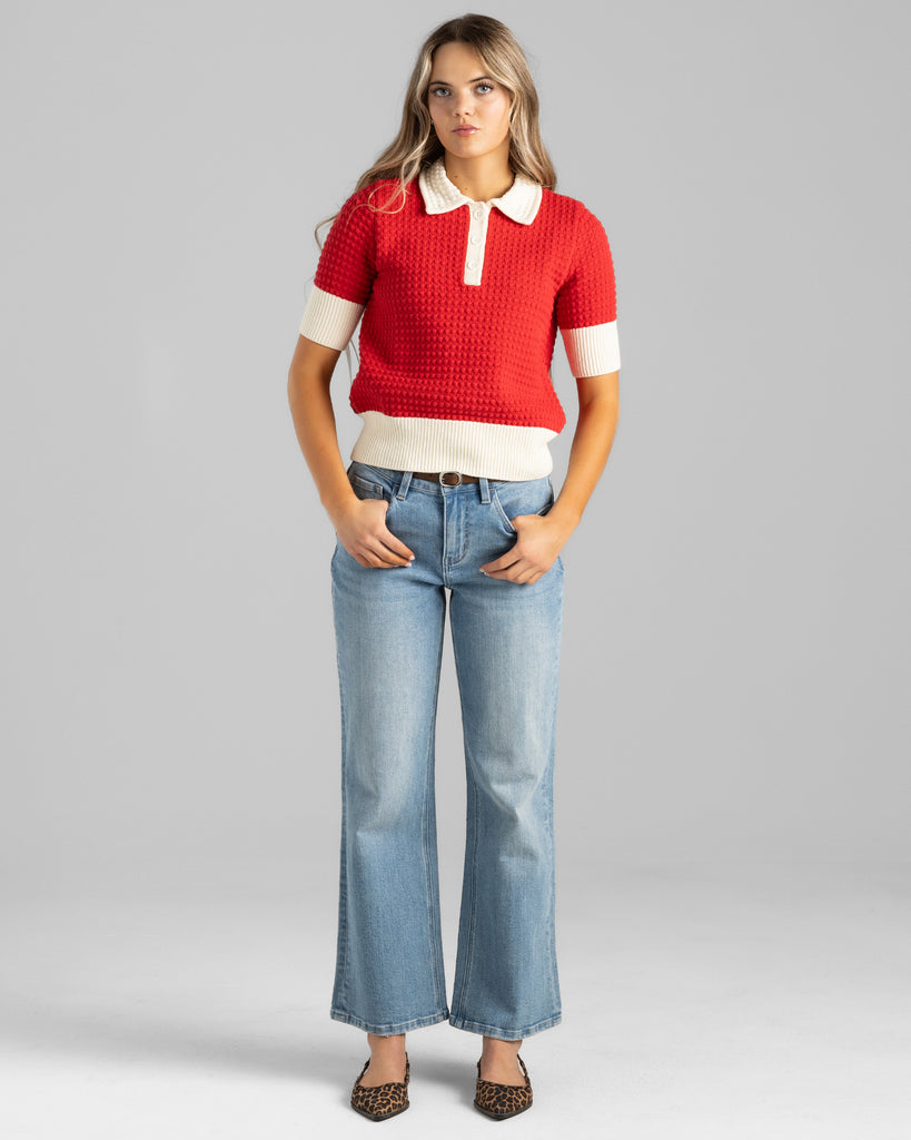 Model wearing blue washed flared ankle length jeans