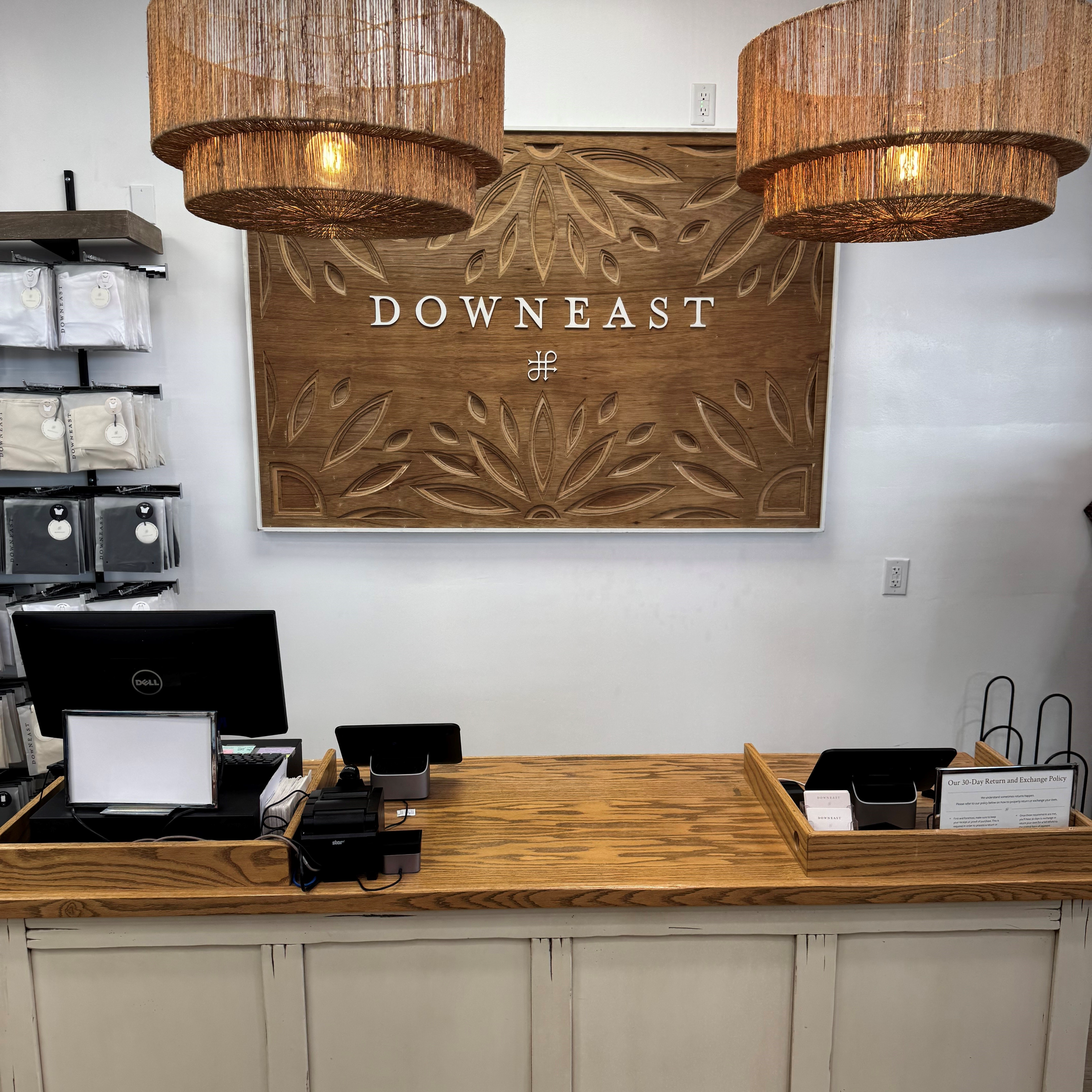 Store interior with 'Downeast' sign above a cashier counter, surrounded by decorative lights and shelves.