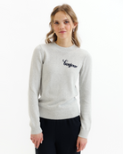 Woman wearing a gray sweater with black embroidered text that says 'bonjour' on a white background
